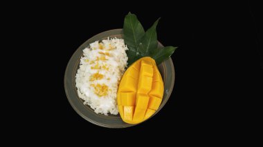 Siyah zemin üzerinde yapışkan pirinç olan mango..