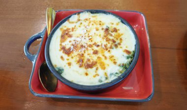 Fransız ıspanağı Gratin tarifi, ahşap masada peynirli ıspanak olarak bilinir..