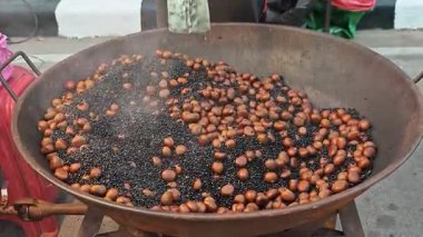 Taze kavrulmuş kestaneler büyük, metalik bir tavanın içine istiflenir..