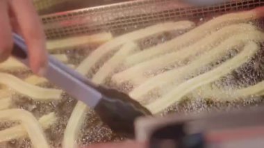 Sıcak yağa batırılmış büyük bir hortumun içinden Churro özü.