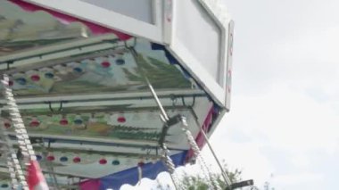Güneşli bir günde tema parkında dönen zincir atlıkarınca.