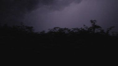 Karanlık bir arka planda yağmurlu bir günde gökyüzünden yıldırımlar yağar. Fırtınalı gökyüzü ile gerçek şimşek