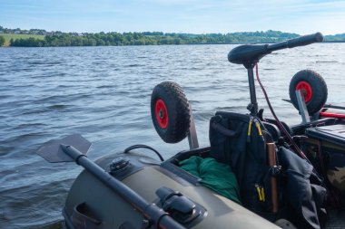 Üzerinde kürek ve giysi çantası olan bir tekne. Kürek teknenin sol tarafında.
