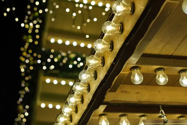 Işıklar parlıyor ve parlıyor. Işıklar ahşap bir yapının üzerinde. Işıklar bir Noel ağacında.