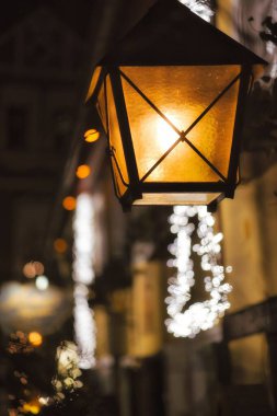 Karanlıkta bir lamba yanar ve etrafını sıcak bir şekilde aydınlatır. Işık buzlu camların arasından parlıyor, yumuşak ve davetkar bir atmosfer yaratıyor. Konfor ve rahatlık kavramı