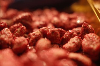 Parlak jöleli kırmızı fındıklı yakın plan. Fındıklar üst üste yığılır ve görsel olarak çekici ve iştah açıcı bir görüntü oluşturur.