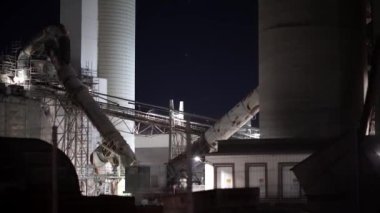 Bir sürü makinası ve borusu olan büyük bir sanayi fabrikası. Bitki gece aydınlanır.