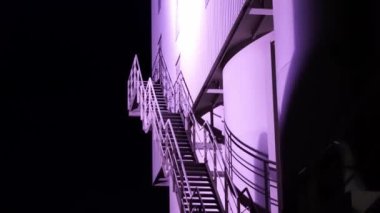 Mor merdivenli bir bina. Merdiven aydınlandı ve bina karanlığa gömüldü.