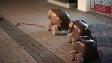 İki oyuncak araba tuğla kaldırımda. Arabalardan biri kahverengi, diğeri siyah.