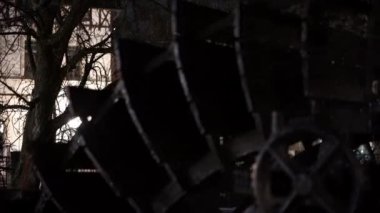 Karanlıkta büyük, eski moda bir su çarkı gösteriliyor. Sahne esrarengiz ve ürkütücü, tekerlek karanlık ve gölgelerle çevrili. Tekerlek terk edilmiş ve unutulmuş görünüyor.