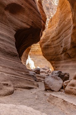 Ortasında büyük bir kaya olan dar bir kanyon. Kanyon kayalarla çevrili ve çok fazla kir var.