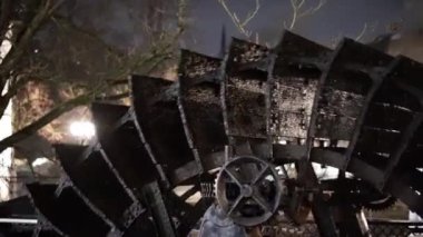 Karanlıkta büyük, eski moda bir su çarkı gösteriliyor. Tekerlek bir ormanla çevrili ve o bakımsız durumda. Sahne kasvetli ve melankoliktir