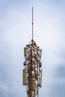Mavi gökyüzü ve hareket eden bulutlarla iletişim kulesi. Ağ kulesinin görüntüsü