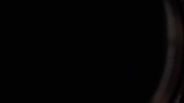 Yeşil ışığı olan karanlık bir odanın siyah beyaz fotoğrafı. Fotoğraf bir insanın gözüdür ve yeşil ışık onun üzerinde parlıyor. Sahne gizemli ve ilgi çekicidir.