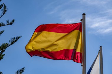 Rüzgarda dalgalanan İspanya bayrağı mavi arkaplan ve kopyalama alanı