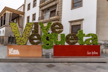 Vive Vegueta işareti Las Palmas de Gran Canaria, İspanya 'da Vegueta mahallesinde görüldü. İşaret binaların önünde duruyor.