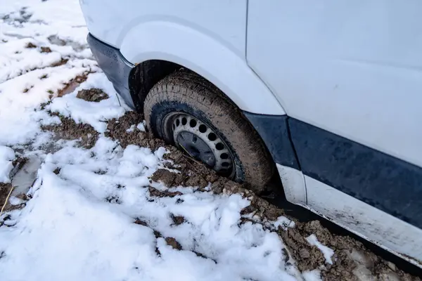 Tekerlekler çok soğuk bir günde çamurlu karda sıkışır..