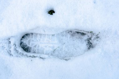 Karda bir ayak izi görülebilir. Yalnızlık ve sessizlik kavramı, tek ayak izinin beyaz kara karşı durması gibi