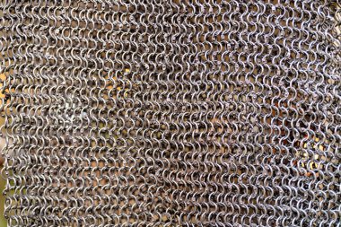 Bir sürü halkası olan metal bir zincirin yakın çekimi. Zincir gümüşten ve pürüzlü bir dokusu var. Güç ve dayanıklılık kavramının yanı sıra tarih ve gelenek duygusu.