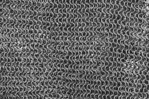 Bir sürü halkası olan metal bir zincirin yakın çekimi. Zincir gümüşten ve çok karmaşık bir tasarımı var.