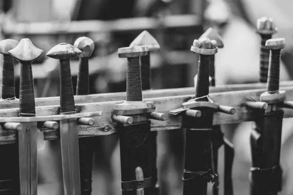 Bir sıra kılıç askıda asılı duruyor. Kılıçların hepsi farklı boyutlarda ve stilde. Sahne merak ve entrikanın bir parçasıdır. Seyirci her kılıcın ardındaki tarih ve hikayeleri merak eder.