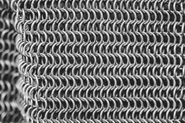 Pek çok küçük halkası olan metal bir zincirin yakın çekimi. Zincir gümüşten ve çok karmaşık bir tasarımı var.