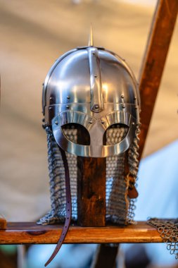 Üzerinde sivri sivri uçlu bir başlık. Miğfer metalden yapılmış ve bir ağ örtüsü var. Tahta bir standın üzerine konur.