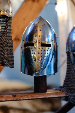 Üzerinde haç olan gümüş bir kask ahşap bir rafta sergilenir. Miğfer zincirli bir tel örgüyle çevrili, bu da ona görüntüde olduğunu hissettiriyor.