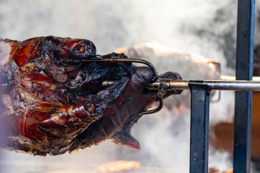 Aşçının domuzu sıcak kömürlerin üstünde dumana tükürülüyor. Açık hava ızgarası