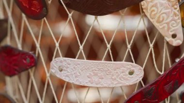 Bir ipten sarkan boncuk ve tılsım koleksiyonu. Boncuklar çeşitli şekil ve boyutlarda ve ip ince, beyaz bir maddeden yapılmış. Sahne yaratıcılık ve bireyselliktir.