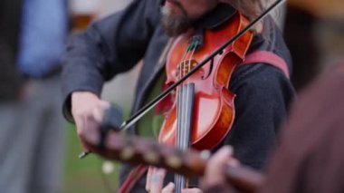 Boynunda kayışla keman çalan bir adam. Tutku kavramı ve müziğe bağlılık