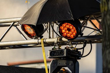 Siyah bir şemsiye iki ışığı örtüyor. Şemsiye ışıkları kapatıyor ve görünür değil.