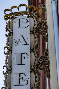 Üzerinde taç olan bir kafe tabelası. Tabela eski ve çok detay içeriyor.