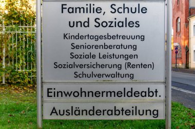 A sign that says Family, School and Societies. It is in German. The sign is on a fence clipart