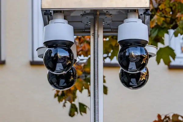 Dört siyah kamera bir direğe monte edilmiştir. Kameralar siyah beyaz ve farklı açılarda konumlandırılmış. Olay yeri güvenlik kamerası kurulumuna benziyor.