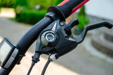 Gümüş zinciri ve gümüş gidonu olan siyah bir bisiklet. Gidonun siyah ve kırmızı bir kolu var.