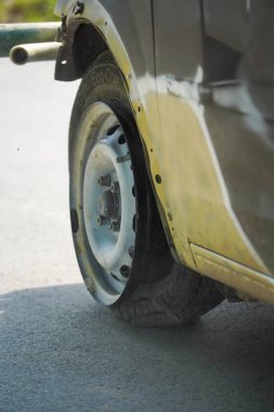 Patlak lastikli bir araba yolun kenarına park edildi. Lastik kayıp ve arabanın tamire ihtiyacı var.