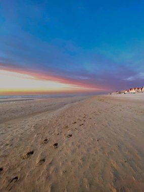 Sahilin yan görüntüsü büyüleyici mimarisi ve canlı günbatımı renkleriyle