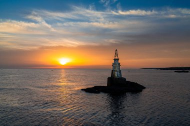Gündoğumunda Bulgaristan 'ın Karadeniz kıyısındaki Athopol' daki küçük deniz fenerinin manzarası