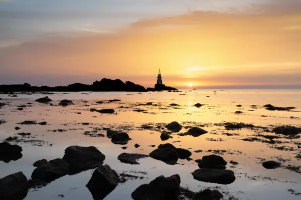 Liman feneri ve kayalık kıyı şeridiyle Atina 'daki Bulgar Karadeniz kıyısında güneşin doğuşunun manzarası