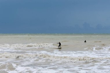 Birling Gap, Birleşik Krallık - 9 Eylül 2022: Doğu Sussex 'teki İngiliz Kanalı' nın fırtınalı denizlerinde dalgalı bir dalgada sörfçü