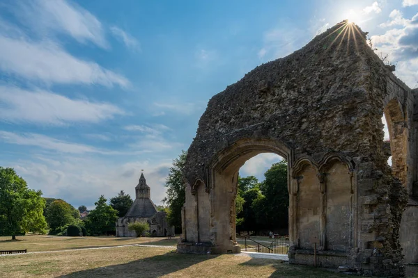 stock image Glastonbury, United Kingdom - 1 September, 2022: view of the ruins of the Choir at the Glastonbury Abbey with a sunburst in the corner