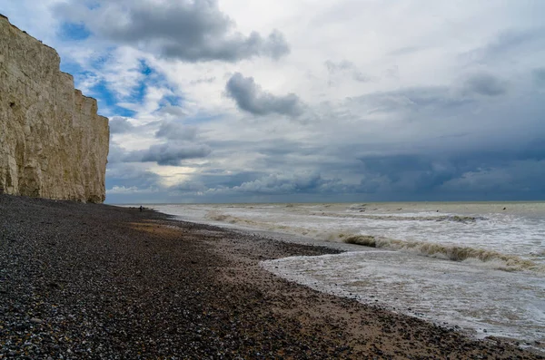 英国侏罗纪海岸一个有着高大石崖的黑色岩石海滩景观 — 图库照片