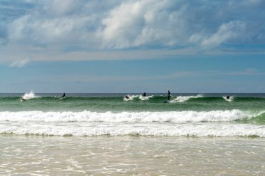 Newquay, Birleşik Krallık - 4 Haziran 2022: sörfçüler Fistral Sahili 'ndeki dalgaların tadını çıkarıyorlar.