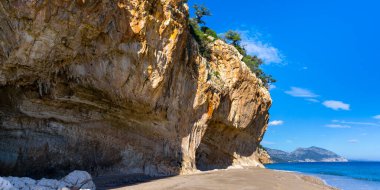 Sardunya 'nın doğu kıyısındaki Cala Luna' nın tepesindeki kayalıklar ve kumlu plajı.