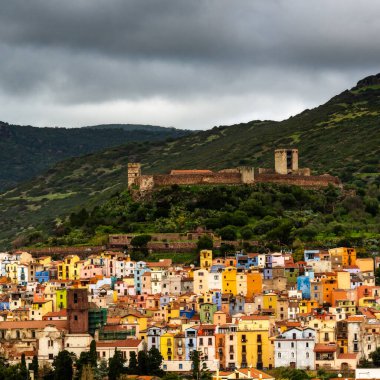 Bosa, İtalya - 13 Aralık 2022: Sardunya 'nın yeşil dağlarındaki renkli eski kasaba ve Bosa Malaspina Kalesi manzarası