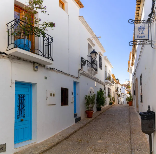Altea, İspanya - 3 Şubat 2023: İspanya Coasta Blanca 'nın tarihi şehir merkezi Altea' da beyaz boyalı ev cepheleriyle dar bir sokak.