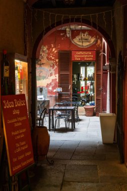 Orta San Giulio, İtalya - 13 Mart 2023: Orta San Giulio 'nun merkezindeki eski püskü bir sokak kafe ve fırının avlu girişi