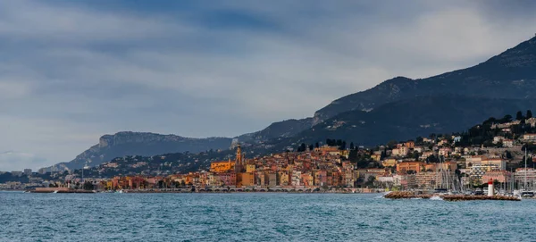 Menton 'un renkli şehir merkezinin panorama manzarası. Önünde mavi Akdeniz var.