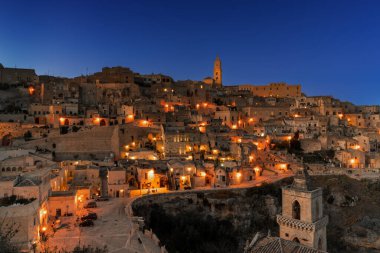 Matera, İtalya - 26 Kasım 2023: Gün batımından sonraki eski Matera kasabasını ışıklar açıkken görmek